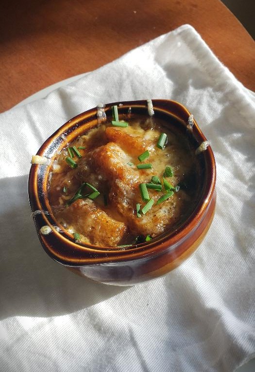 a bowl of French onion soup with cheese and croutons